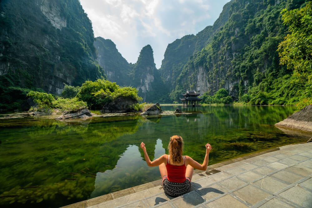 a woman sitting by the water in vietnam